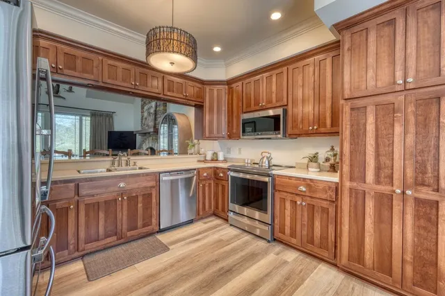 a kitchen with stainless steel appliances granite countertop a refrigerator a stove top oven a sink and dishwasher