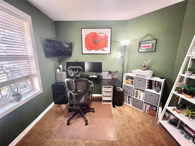 a view of a workspace with furniture and a window