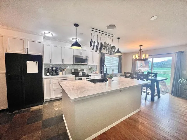 a large kitchen with lots of counter space and chandelier
