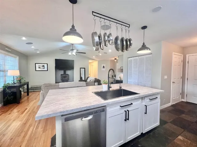 a kitchen with stainless steel appliances granite countertop a sink a refrigerator and a stove