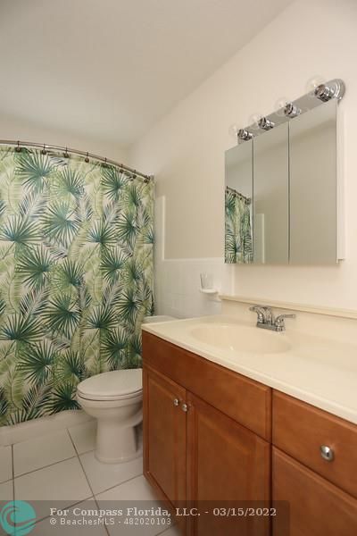 1948 Sailfish Place Lauderdale-by-the-Sea, FL 33062 - Photo 17 of 33 a bathroom with a sink a toilet and mirror