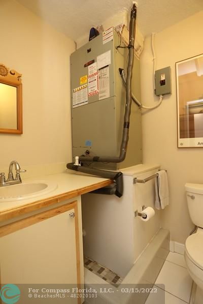 1948 Sailfish Place Lauderdale-by-the-Sea, FL 33062 - Photo 18 of 33 a bathroom with a sink a toilet and a mirror