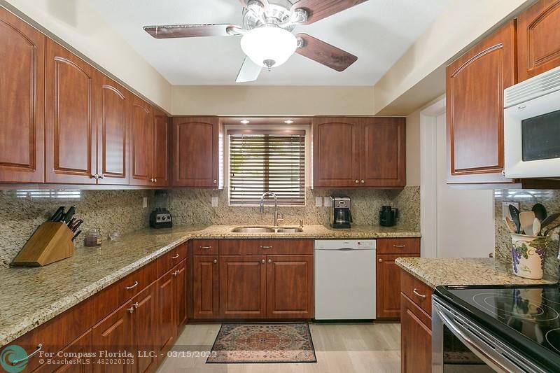 1948 Sailfish Place Lauderdale-by-the-Sea, FL 33062 - Photo 9 of 33 a kitchen with a sink a stove cabinets and a window