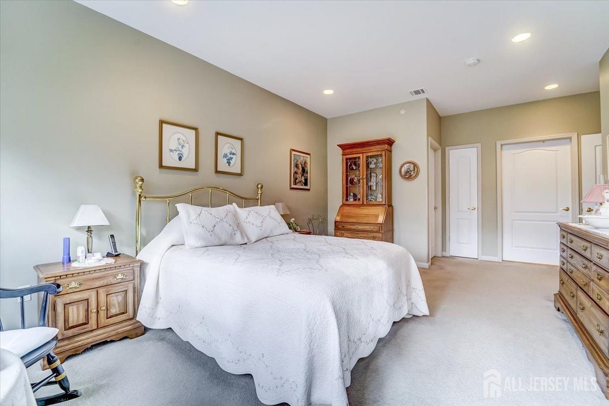 375 Rifle Camp Road, Unit 409 Woodland Park, NJ 07424 - Photo 19 of 22 a bedroom with a large bed and a chandelier