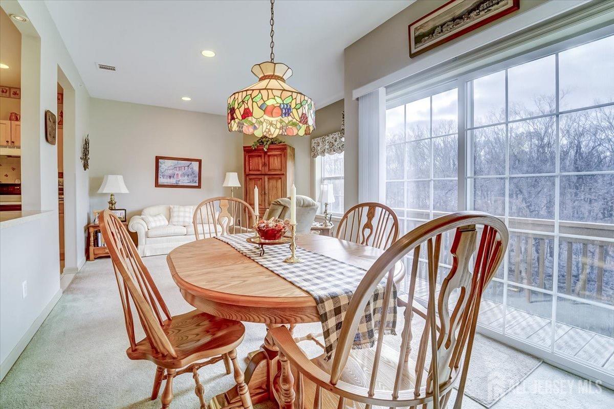 375 Rifle Camp Road, Unit 409 Woodland Park, NJ 07424 - Photo 6 of 22 a dining room with furniture a chandelier and window
