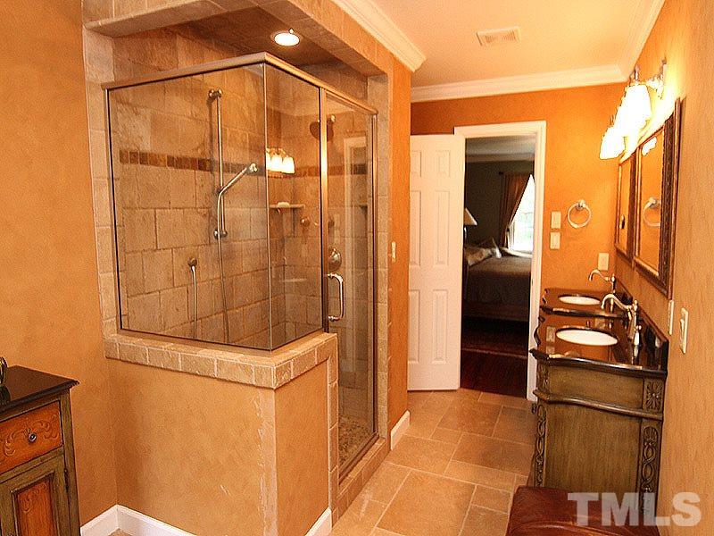 2712 Farnborough Road Raleigh, NC 27613 - Photo 10 of 25 completely remodeled Master Bath in 2008 includes Travertine tiled floors, spacious walk-in shower, separate his and hers furniture vanity sinks, and jacuzzi tub with tile surround. 2 Walk-in closets in Master Suite.