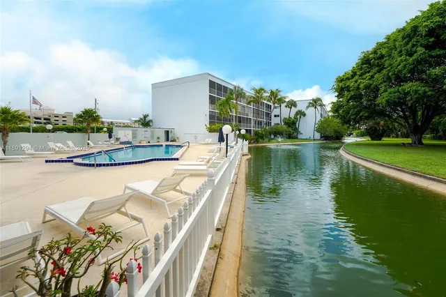 a view of a lake with a yard and potted plants