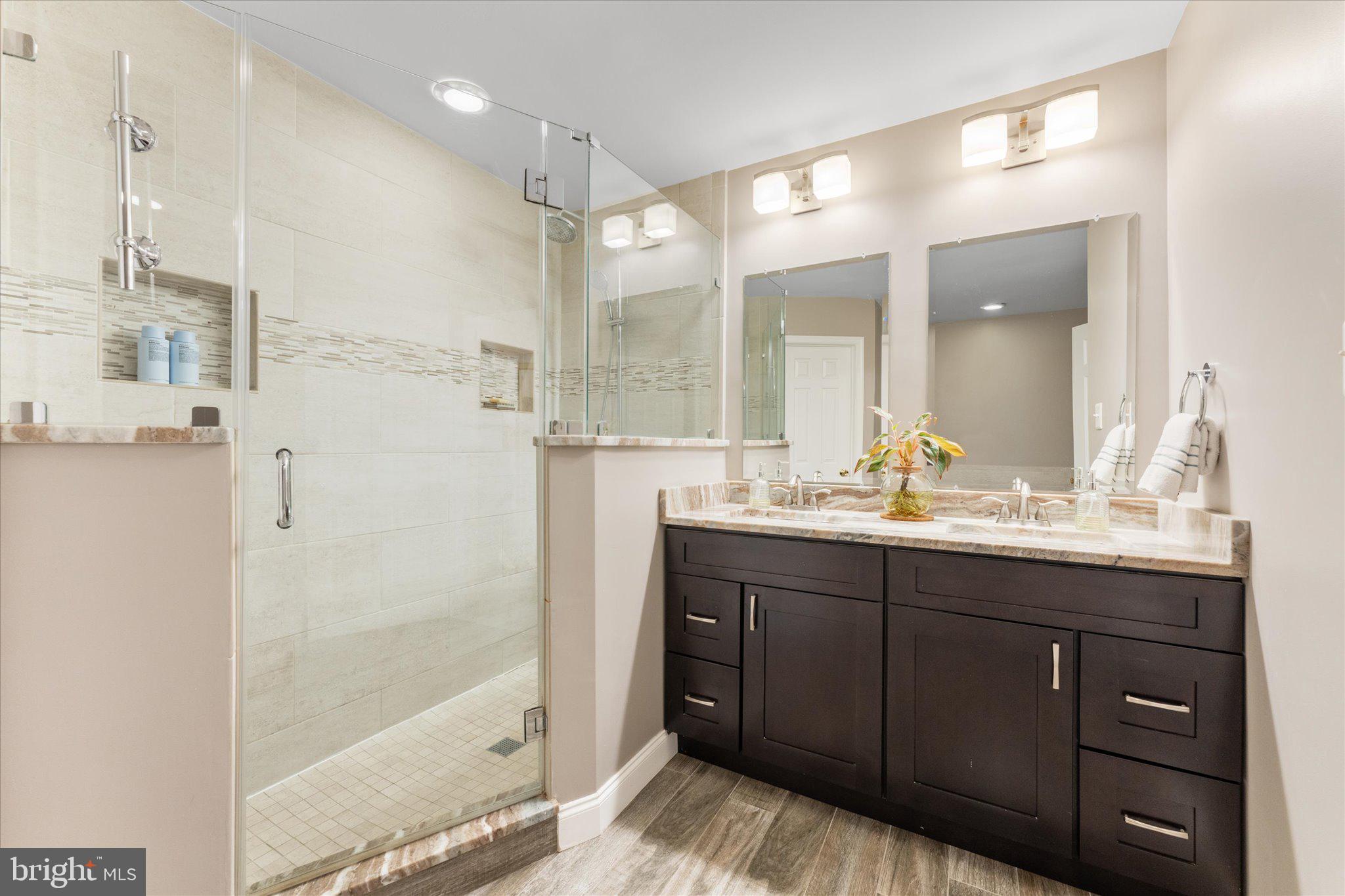 21047 Barcroft Way Sterling, VA 20164 - Photo 25 of 47 a bathroom with a granite countertop sink mirror and a shower