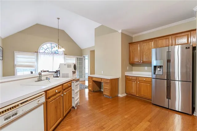 a large kitchen with kitchen island a sink a stove a dining table and chairs