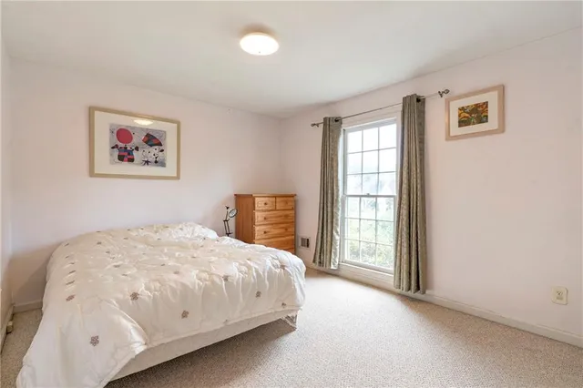 a bed sitting in a spacious bedroom next to a bathroom