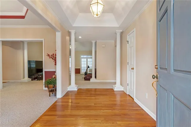 a view of a hallway with wooden floor and chandelier
