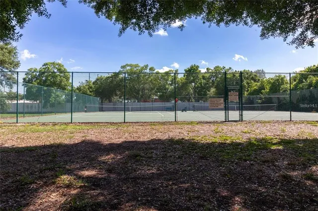 a view of a tennis ground with a park