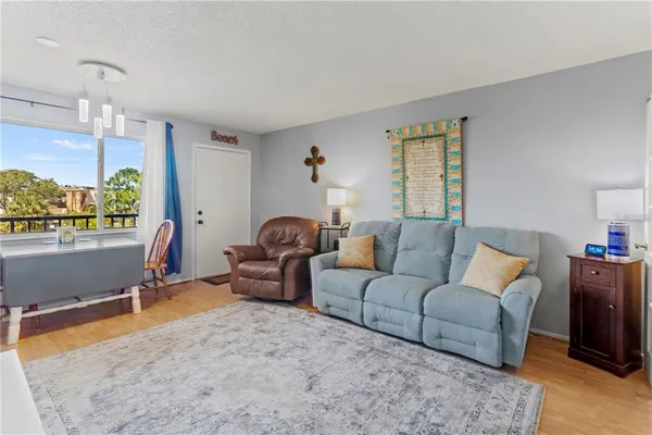 a living room with furniture a window and a flat screen tv