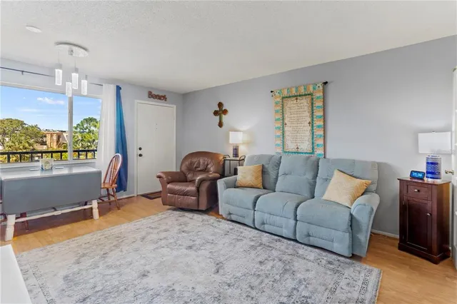 a living room with furniture a window and a flat screen tv
