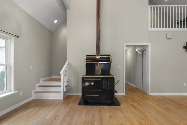 a view of empty room with wooden floor and fireplace