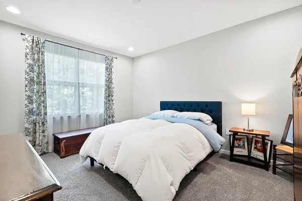 a bed sitting in a bedroom next to a window