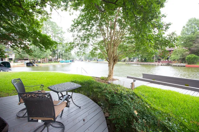 a view of backyard with outdoor seating and trees in the background
