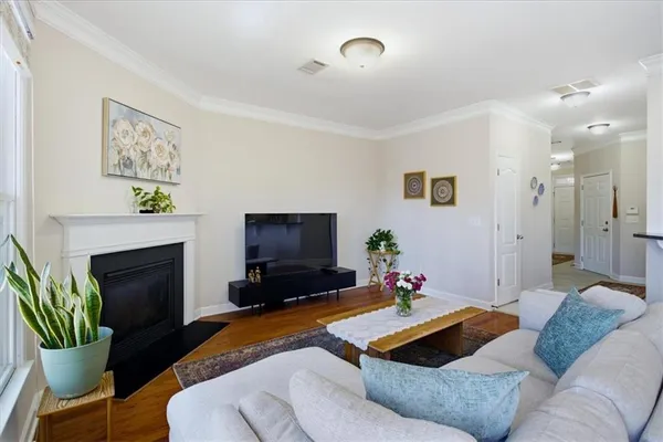 a living room with furniture a flat screen tv and a fireplace