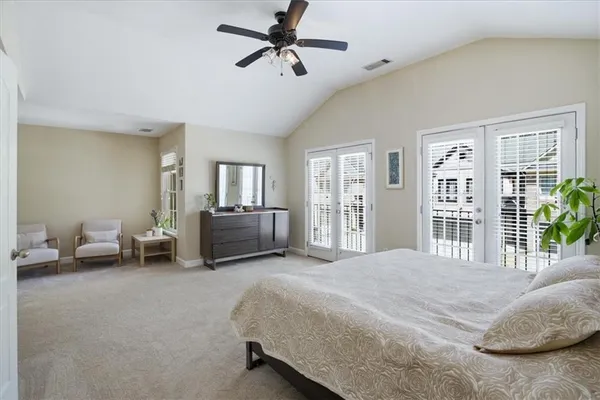 a spacious bedroom with a bed and a chandelier