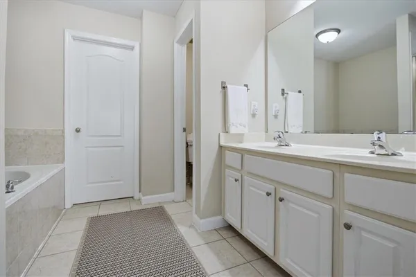 a bathroom with a double vanity sink a mirror and a bathtub