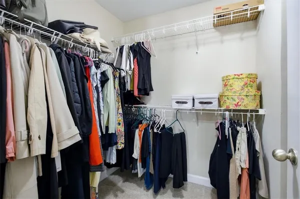 a view of walk in closet with clothes and shoes