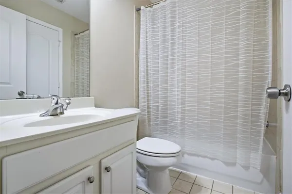 a bathroom with a toilet a sink a shower and a mirror