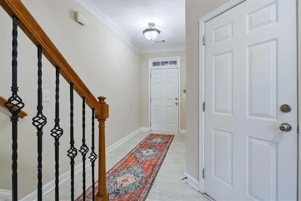 a view of a hallway with wooden floor and staircase