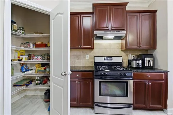 a kitchen with stainless steel appliances granite countertop wooden cabinets and a stove top oven