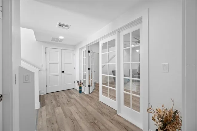 a view of a hallway with wooden floor and a bathroom