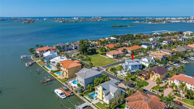 an aerial view of ocean and residential houses with outdoor space