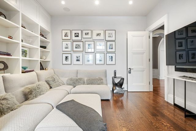 a living room with white furniture and a chandelier