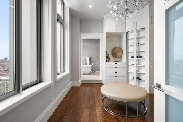a view of walk in closet with clothes shoes and a mirror