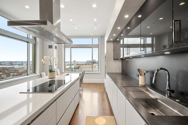 a large kitchen with kitchen island a large window and stainless steel appliances