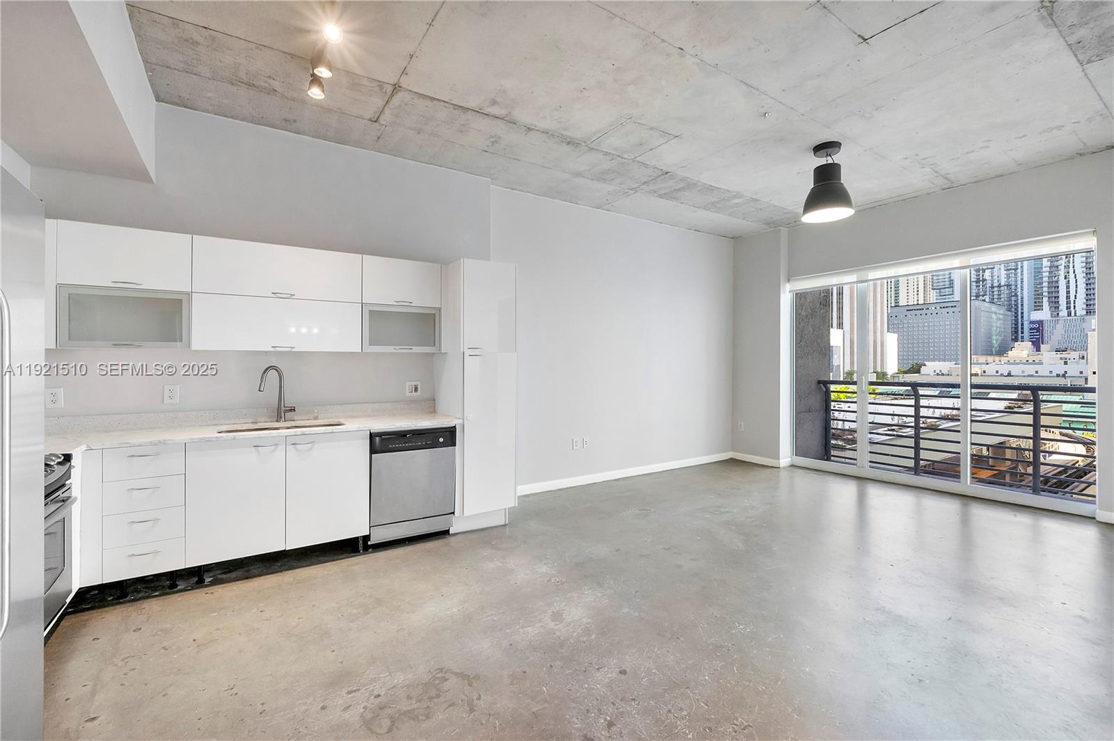 133 Northeast 2nd Avenue, Unit 508 Miami, FL 33132 - Photo 7 of 17 a kitchen with granite countertop a stove a sink and white cabinets with wooden floor