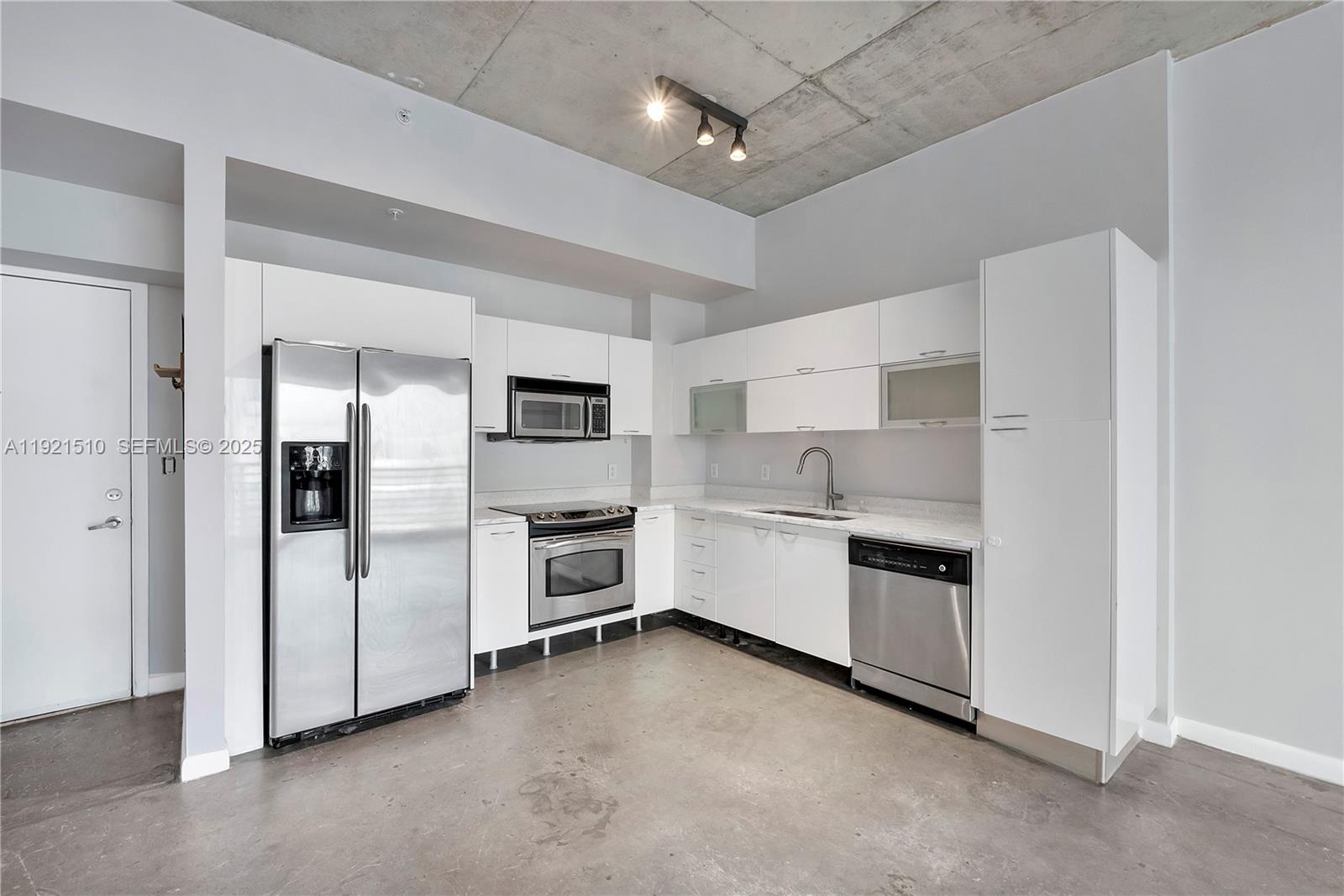 133 Northeast 2nd Avenue, Unit 508 Miami, FL 33132 - Photo 8 of 17 a kitchen with white cabinets and stainless steel appliances