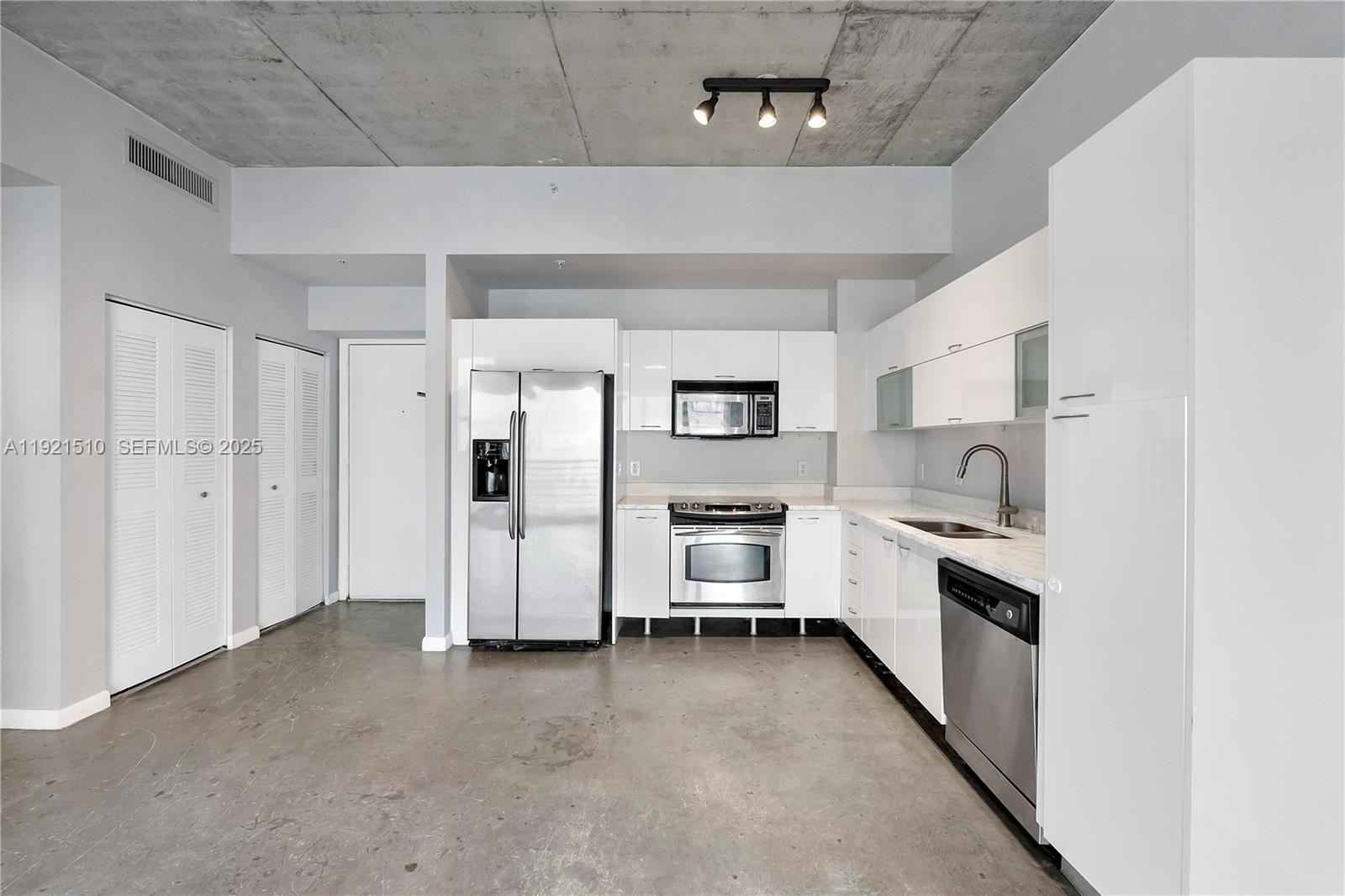 133 Northeast 2nd Avenue, Unit 508 Miami, FL 33132 - Photo 9 of 17 a kitchen with stainless steel appliances a refrigerator a sink a stove and white cabinets