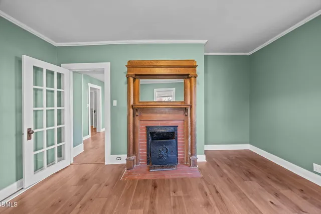 a view of a livingroom with a fireplace a chandelier and wooden floor
