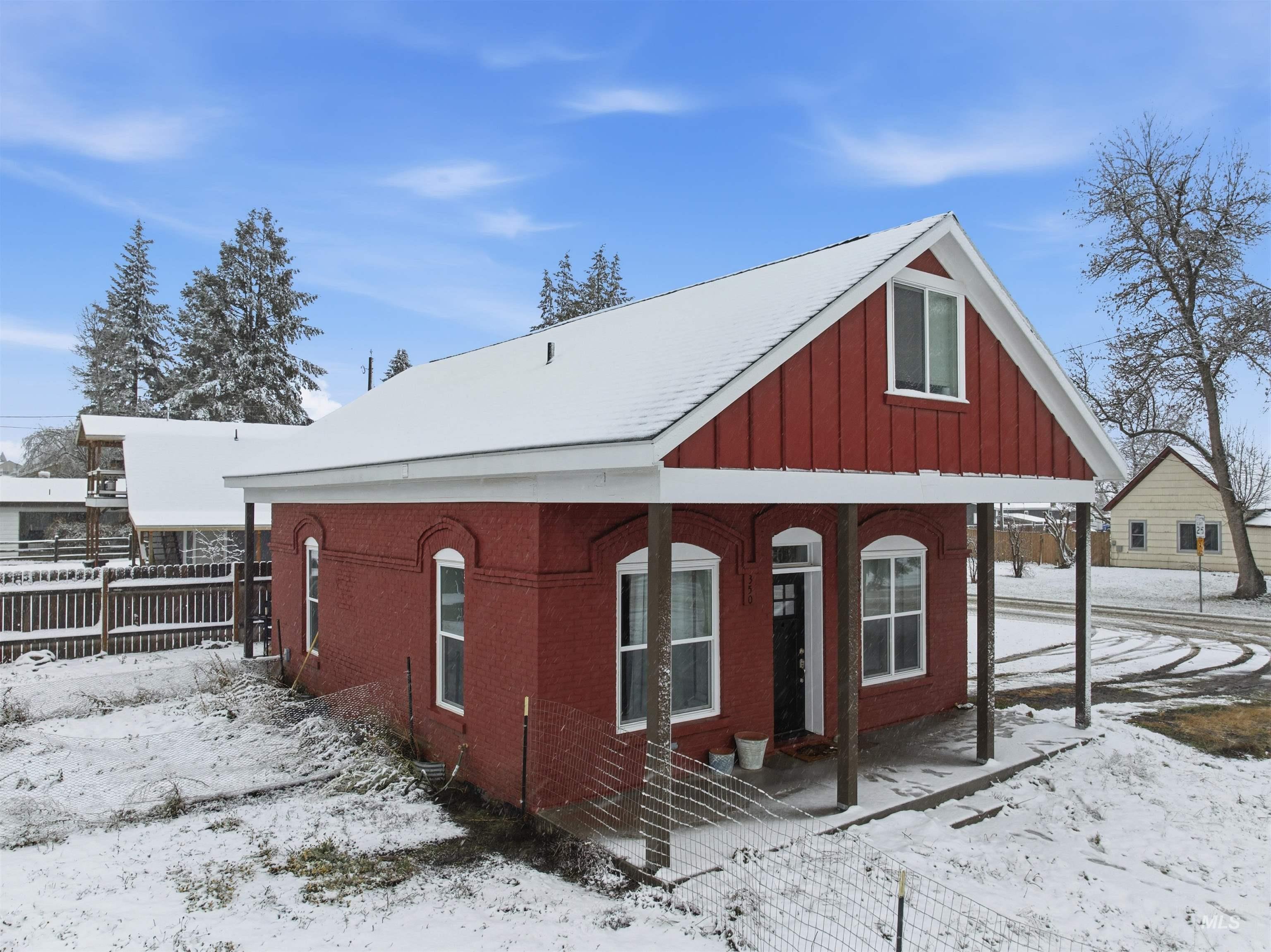 View of snow covered exterior featuring a porch and board and batten siding