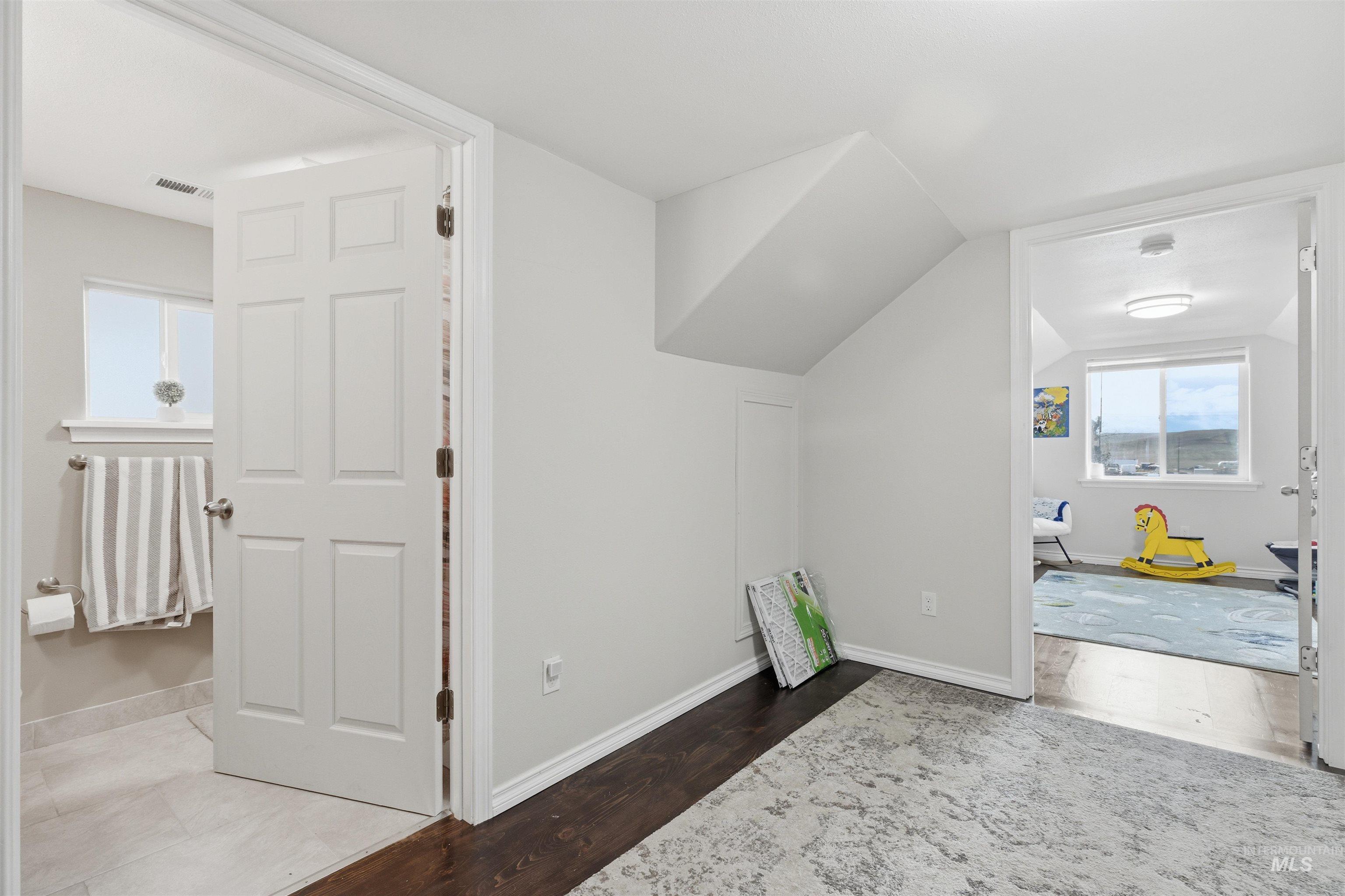 350 East Walnut Avenue Genesee, ID 83832 - Photo 12 of 27 Additional living space with dark wood finished floors and lofted ceiling