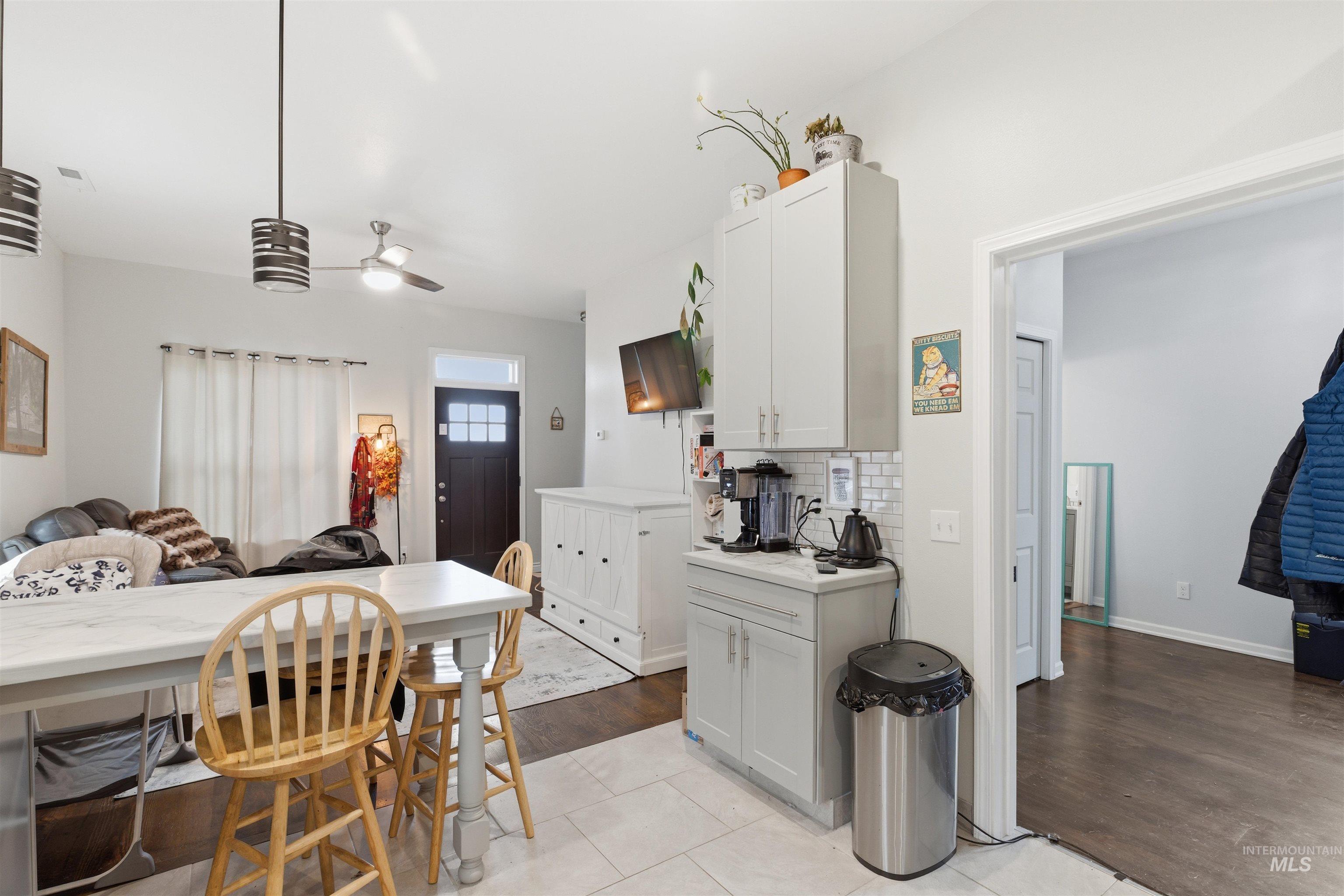350 East Walnut Avenue Genesee, ID 83832 - Photo 27 of 27 Kitchen with light countertops, open floor plan, backsplash, white cabinets, and decorative light fixtures