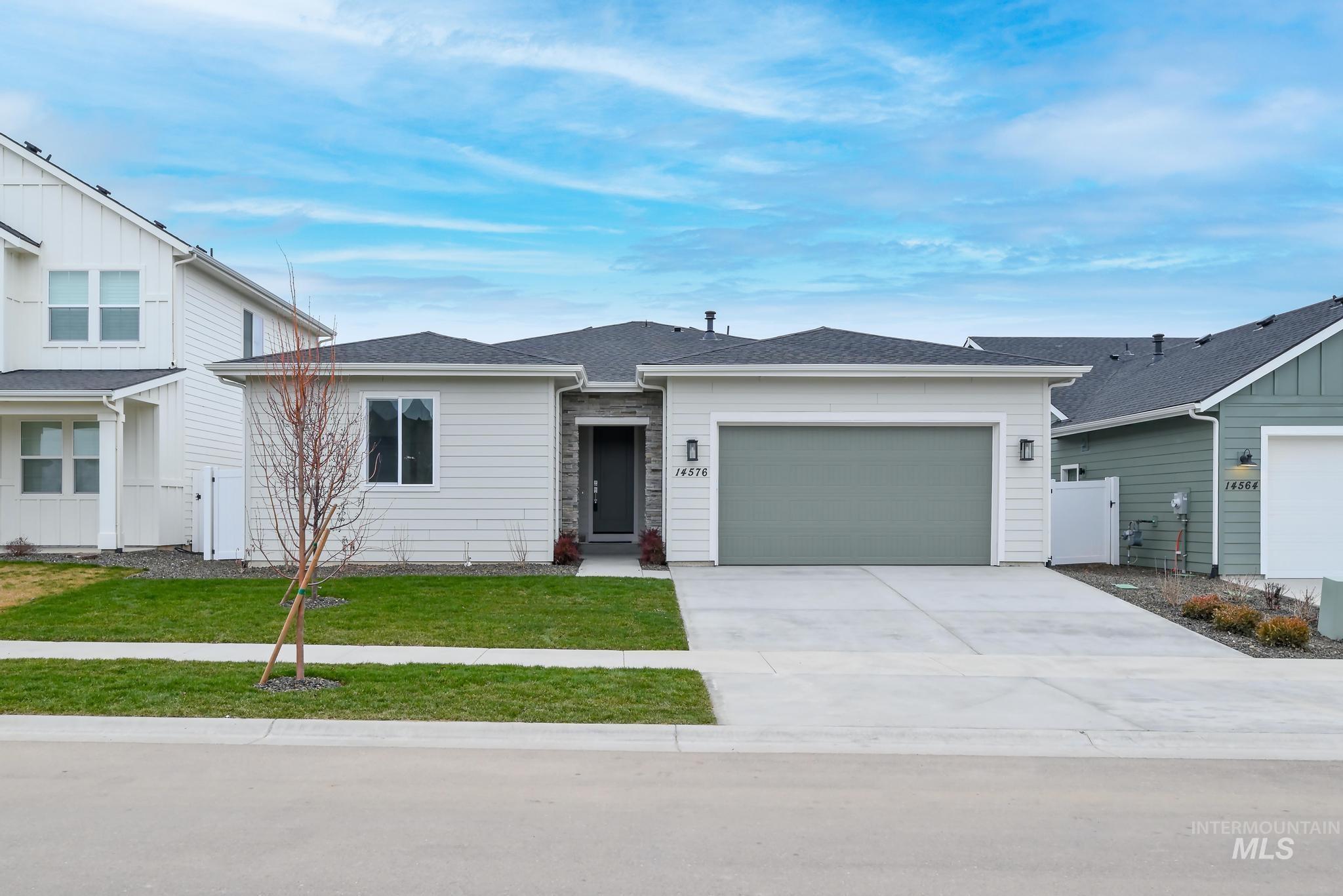 View of front of home featuring a garage, concrete driveway, and roof with shingles