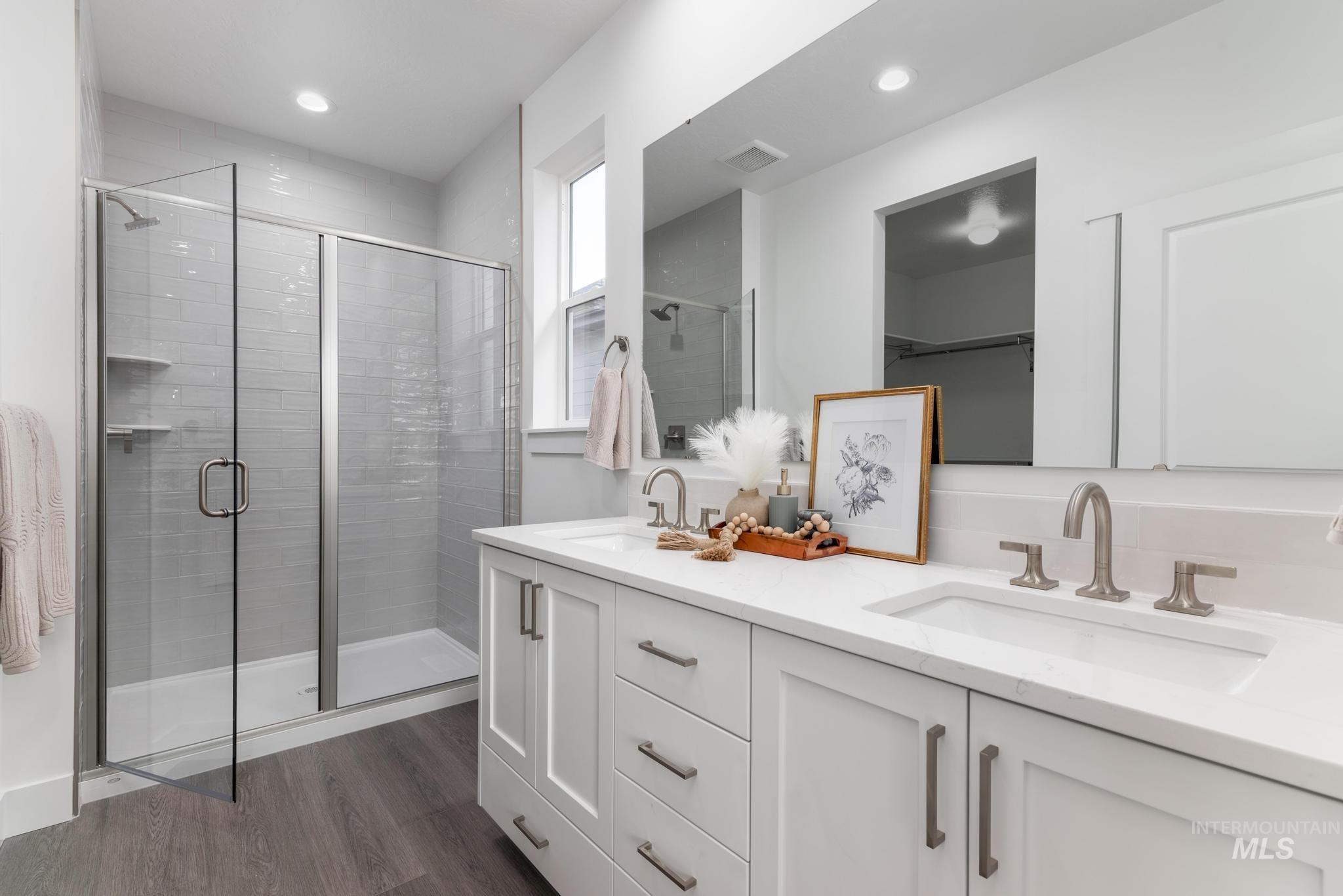 1761 West Arya Street Kuna, ID 83634 - Photo 10 of 12 Full bathroom with double vanity, a shower stall, dark wood-type flooring, and recessed lighting