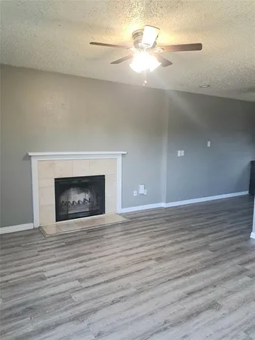 a view of empty room with wooden floor and fireplace