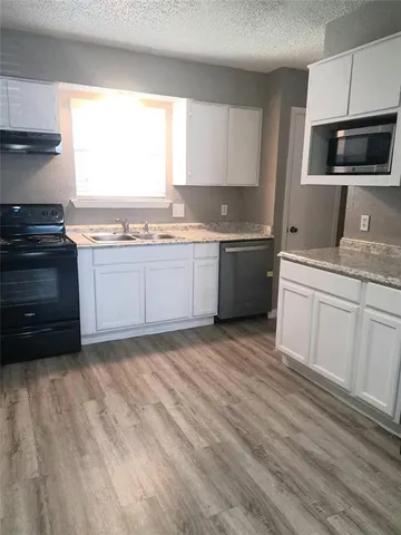 a kitchen with a sink stove and microwave