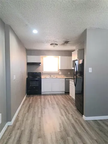a kitchen with granite countertop a refrigerator and a sink