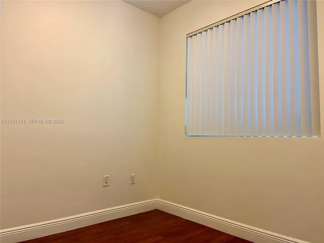 a view of a small space with wooden floor and a window