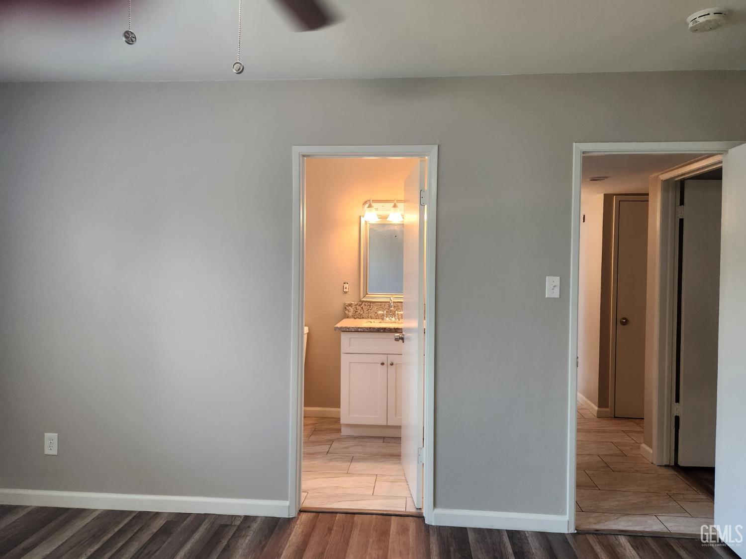 Undisclosed Address Bakersfield, CA 93309 - Photo 11 of 22 a view of a hallway with wooden floor and a bathroom
