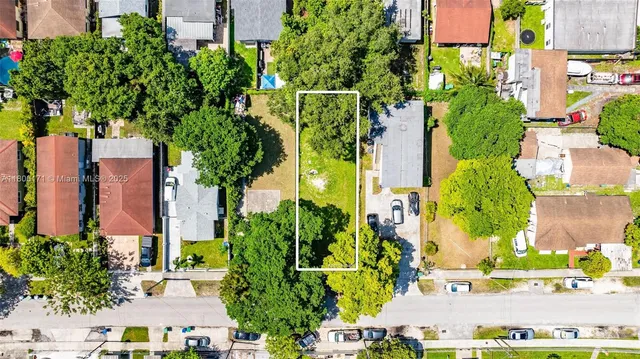 an aerial view of a residential apartment building with a yard and plants