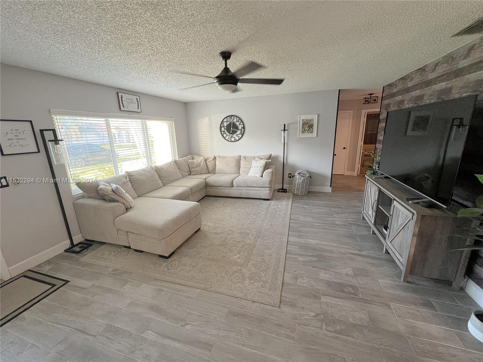 4941 Alfresco Street Boca Raton, FL 33428 - Photo 3 of 20 a living room with furniture and a flat screen tv