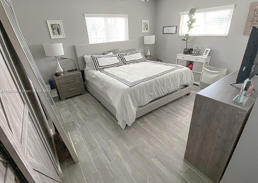 4941 Alfresco Street Boca Raton, FL 33428 - Photo 8 of 20 a bedroom with a bed and wooden floor